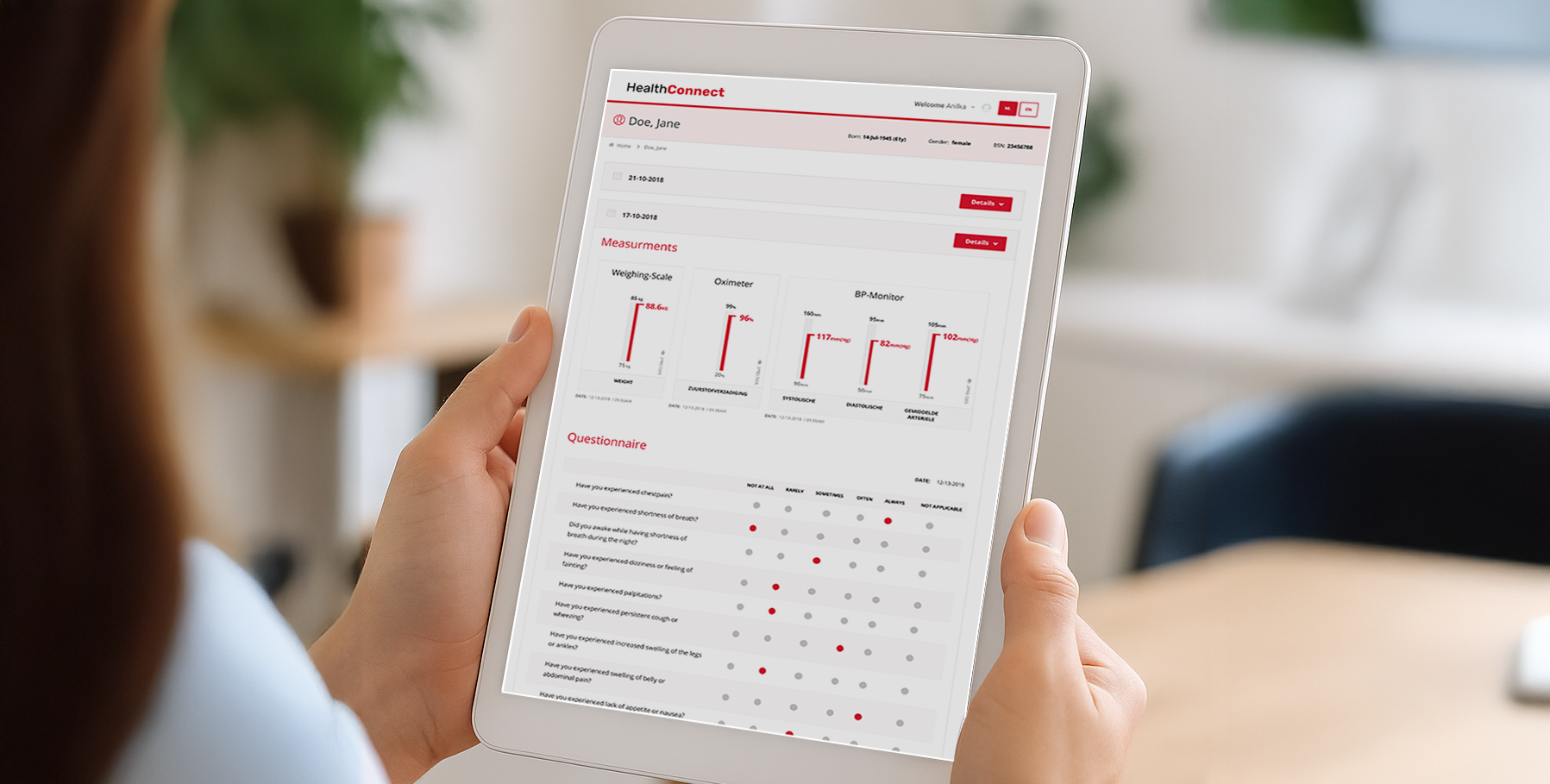 Clinician holding a tablet showing a patient’s measurements and questionnaire